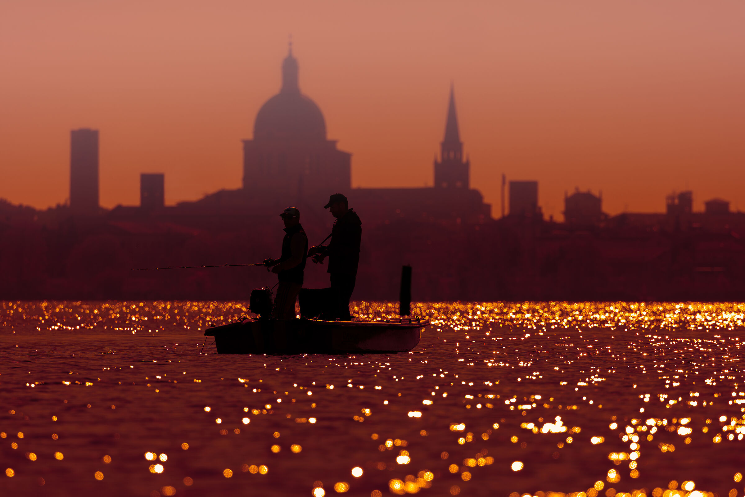 Pescatori in controluce sullo sfondo di Mantova...