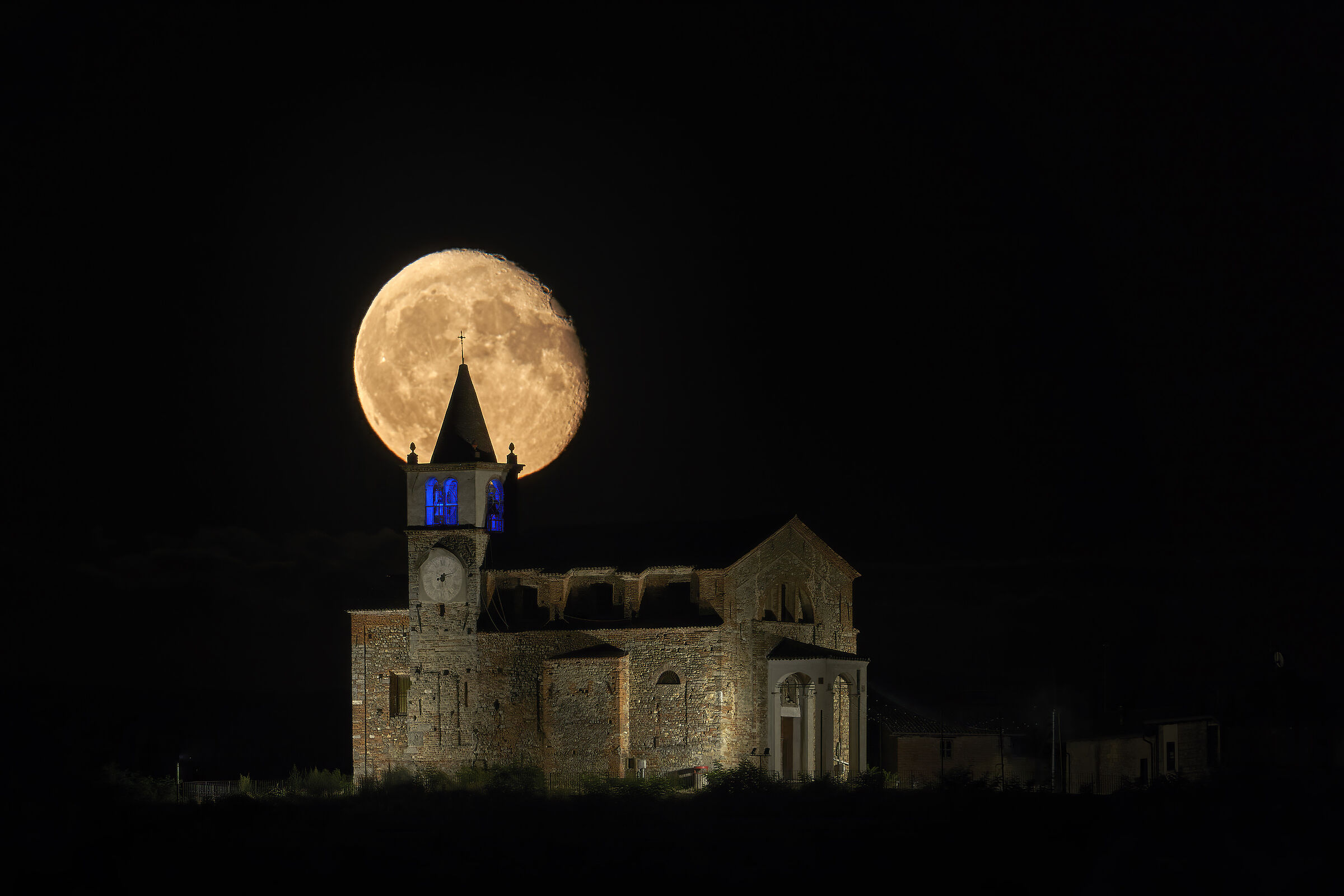 The moon rises behind the church of my village...