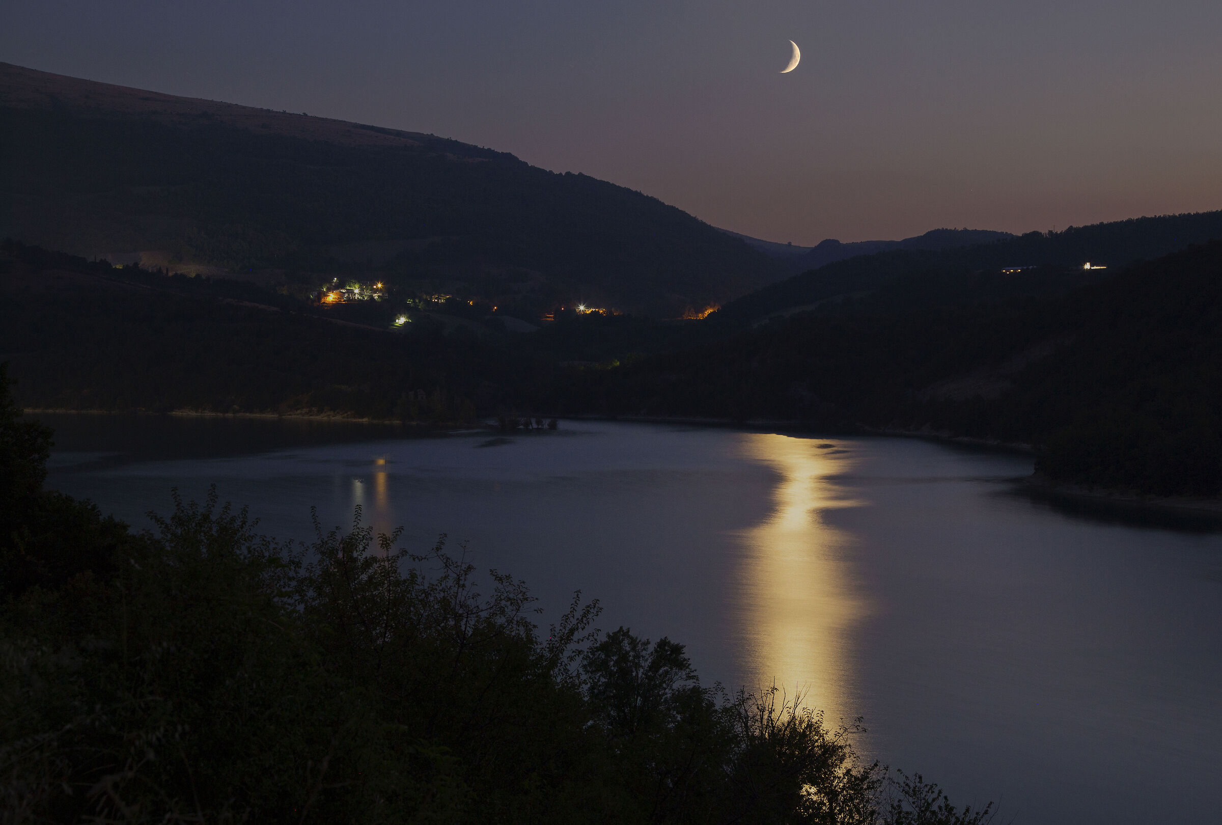 Uno spicchio di Luna crescente si riflette sul lago .....