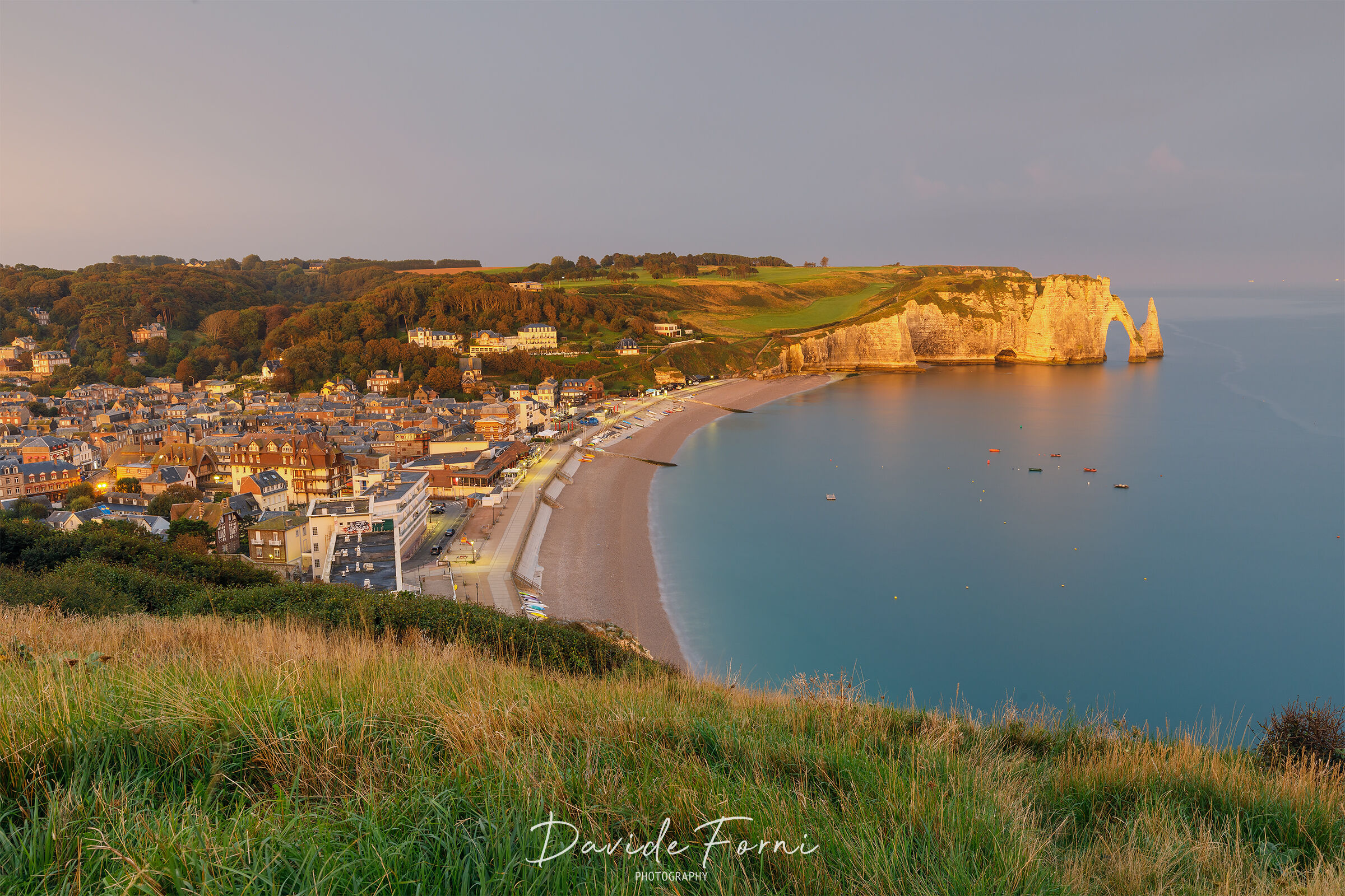 Sunrise over the village of Etretat and the Falesia d'Ava...